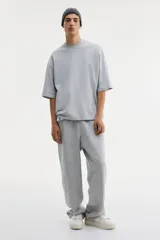 Remera de algodón pesado color gris melange, con cuello redondo ribeteado, hombros caídos y corte oversized.