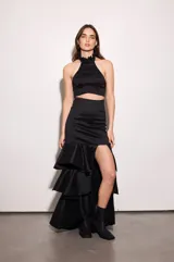 Top negro de tafeta con escote halter, volados en el cuello, espalda baja y cierre con botones.