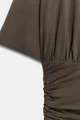 Vestido corto de manga corta y cuello redondo, confeccionado con mezcla de algodón. Presenta un diseño ajustado con drapeado lateral en la falda.
