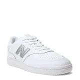 Championes urbanos New Balance modelo Court, color blanco con logo lateral plateado texturizado. Presentan puntera perforada para mayor ventilación y suela de goma al tono.