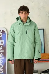 Campera técnica de abrigo en color verde menta, con capucha ajustable, cierre frontal con solapa, bolsillos con cierre y puños ajustables. Diseño funcional ideal para actividades al aire libre.