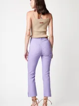 Pantalón de gabardina elastizada color lila, de pierna recta con largo arriba del tobillo y tajos en el ruedo. Tiene cierre delantero, botón, bolsillos laterales y traseros.