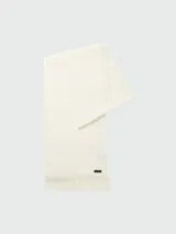 Bufanda de punto Raschel color blanco hueso, con diseño liso y terminación en flecos cortos. Incluye una pequeña etiqueta metálica con el logo de la marca.