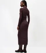 Vestido midi de tul con estampado sutil, de corte ajustado, cuello alto y mangas largas. Presenta un diseño con transparencias y forro interno parcial.