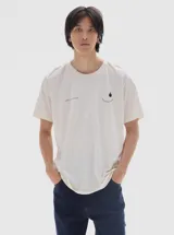 Remera de algodón con lavado efecto gastado, cuello redondo y manga corta. Presenta un pequeño estampado minimalista en el pecho con una sonrisa y una gota, junto con una inscripción cursiva.