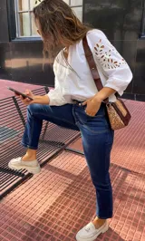 Pantalón de jean azul oscuro, corte recto, tiro alto y detalles de costuras en la parte superior.