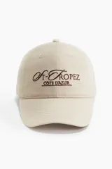 Gorra de sarga color beige con bordado marrón de la frase "St-Tropez Cote D'Azur".