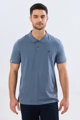 Remera polo de manga corta en color azul melange, con cuello camisero, cierre frontal de dos botones y pequeño bordado en el pecho.