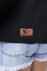 Campera de jean negra, de corte oversize, con cuello camisero, botones dorados y bolsillos frontales con solapa.