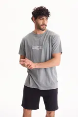 Remera de algodón gris de manga corta con calce semi boxy y pequeño estampado tipográfico en el centro del pecho.