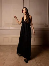 Vestido largo color marrón con bordados florales a tono, escote en V y corte imperio. Tiene falda amplia con volados y breteles finos.