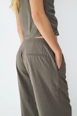 Pantalón de corte recto y tiro medio, confeccionado en tejido crepé con diseño de raya diplomática. Presenta una caída fluida, bolsillos laterales y cierre frontal.