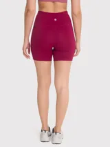 Calza corta deportiva color borgoña, de tiro alto, con bolsillos laterales y banda de silicona en la cintura.