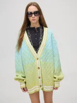 Cardigan de punto con diseño degradé en tonos tierra, patrón de rombos en relieve, cuello en V con cartera de botones y puños con rayas blancas y marrones.