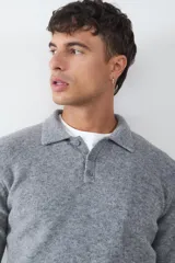 Sweater de punto suave color gris, con cuello polo y cierre frontal de tres botones. Confeccionado en un tejido abrigado.