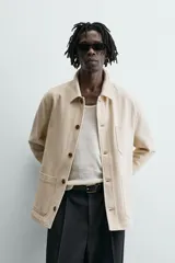 Sobrecamisa relaxed fit color beige, confeccionada en tejido de algodón. Cuenta con cuello solapa, manga larga con puño abotonado, bolsillos plastrón en el delantero y cierre frontal de botonadura.