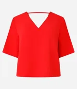Blusa Cortelle de corte holgado confeccionada en crepé, con escote en V delantero y trasero, y mangas cortas. Presenta una tira decorativa entre los hombros en la espalda.