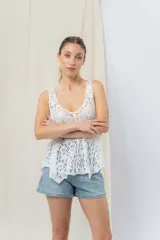 Musculosa blanca de encaje calado con diseño floral, escote en V y breteles anchos.