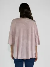 Remera color amarillo con cuello redondo y mangas cortas anchas con detalle de botones en los laterales. Diseño holgado con efecto gastado.