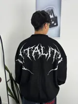 Sweater de punto negro con diseño oversize y estampa gráfica en color blanco en la espalda con tipografía estilo metal.