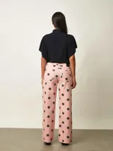 Pantalon tipo jean de corte recto, color rosado con estampa de lunares negros.