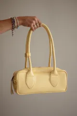 Cartera estilo baguette de cuero color marrón, con doble asa de hombro y cierre de cremallera. Hecha a mano en Uruguay.