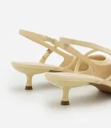 Zapato de tacón color crema, con punta fina, tira delantera y tira trasera con hebilla.