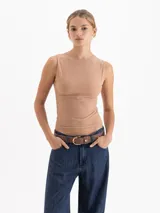 Musculosa de cuello redondo y silueta minimalista, confeccionada en una suave mezcla de poliamida y elastano que ofrece un calce confortable y una gran adaptabilidad al cuerpo. Su diseño sin mangas con hombros sutilmente encajados la convierte en una prenda básica de alta calidad.