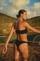 Corpiño strapless negro con plisado y bombacha vedetina embolsada.