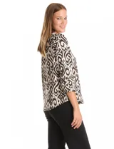 Blusa de seda fría con estampado geométrico tipo ikat en tonos beige y negro. Presenta escote en V, botones decorativos en la parte frontal y mangas tres cuartos con detalle de tajo en los puños.