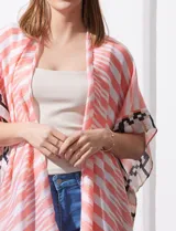 Kimono tejido con estampado de rayas azules y blancas, mangas amplias estilo japonés y terminación de ruedo con borlas azules.