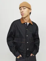 Campera de denim azul oscuro con cuello clásico marrón, cierre frontal con botones metálicos, bolsillos delanteros con solapa y puños con botones. Confeccionada en tejido denim resistente con estructura de sarga.