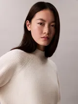 Sweater de punto Calvin Klein color blanco marfil, con diseño acanalado, cuello alto y mangas largas de corte raglán.