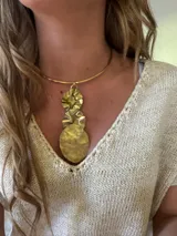 Gargantilla rígida dorada con dije colgante de tres piezas circulares texturizadas.