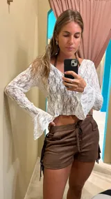 Blusa de encaje blanca con mangas largas acampanadas.