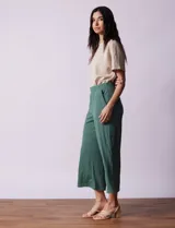 Pantalón capri plisado color beige, marca Dictionary, con pretina ancha elastizada y bolsillos delanteros.