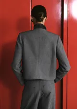 Blazer cropped gris de cuello redondo y manga larga, con patrón de cuadros, bolsillos de ribete delanteros y cierre de botones.