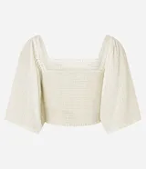 Blusa cropped color blanco, con escote recto, mangas amplias con elástico en los hombros, lastex en el cuerpo y textura.