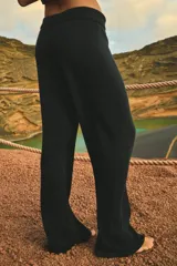 Pantalón tejido en algodón color negro, con cintura ancha en rib con elástico interno y tiras regulables. Diseño moderno y fluido.