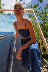 Jean de tiro bajo y corte oversize, confeccionado en denim azul con grabado láser de monograma en patrón de rombos. Presenta avíos metálicos y diseño de pierna ancha.
