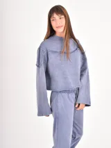 Buzo corto de cuello redondo con efecto lavado, mangas largas con puños elásticos y costuras decorativas horizontales en el pecho.