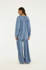 Pantalón tipo babucha de diseño amplio y cómodo, color azul, confeccionado en mezcla de viscosa y algodón. Presenta talle alto, cierre con botón y bolsillos laterales.