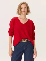 Buzo de lana color rojo, con escote en V y diseño de rombos calados en el frente.