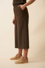 Pantalón palazzo marrón de tiro alto, con bolsillos laterales y largo a la pantorrilla.