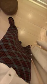 Pollera larga de corte recto con estampado de cuadros en tonos azul, gris y marrón. Presenta un diseño de tiro alto y cierre lateral.