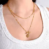 Collar doble de cadena de eslabones alargados en tono dorado, con un dije central en forma de corazón y cierre tipo barra en T.