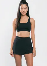 Mini short negro de corte cruzado tipo pollera, con diseño minimalista y ajuste cómodo.