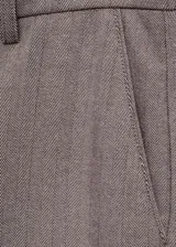 Pantalón de vestir marrón de tiro medio, con diseño crop y corte skinny, trabillas para cinto, bolsillos laterales y cierre oculto con botón, gancho y cremallera.