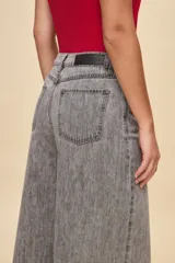 Jean wide leg de tiro alto color celeste, con calce amplio y pierna ancha, diseño de cinco bolsillos y cierre frontal con botón y cremallera.