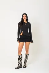 Botas de caña alta con estampado de vaca en blanco y negro, con tacón bajo y puntera redondeada.